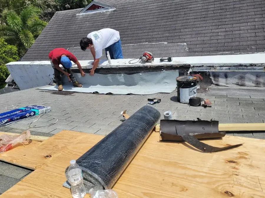 Two roofers installing flat roof membrane in Coral Springs, FL — Broward Roofing Pros