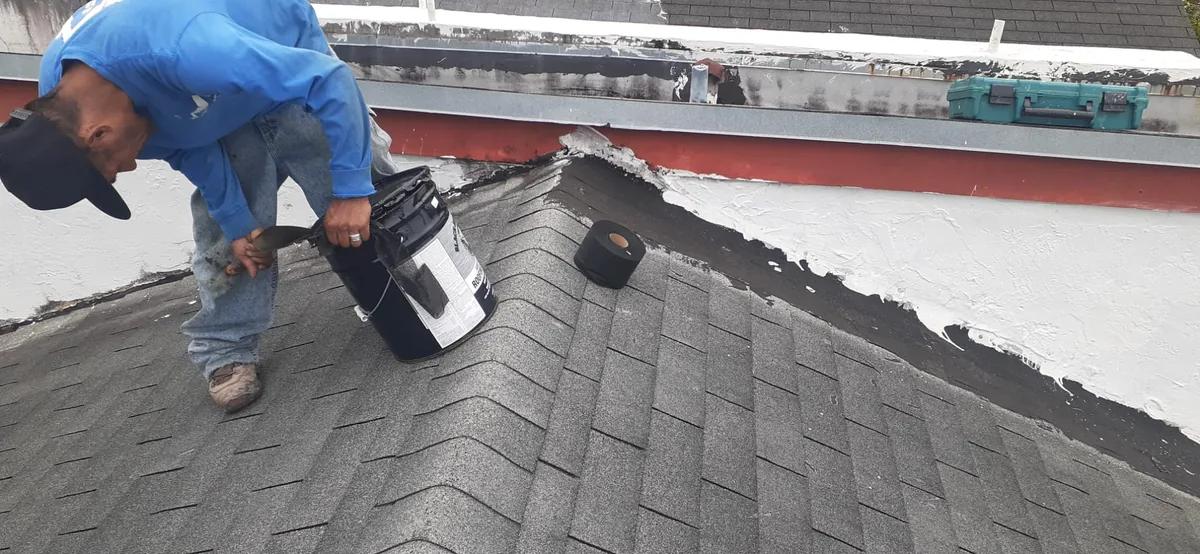 Roof repair technician applying sealant on asphalt shingles in Fort Lauderdale, FL — Broward Roofing Pros