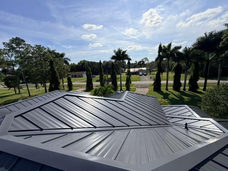 Gray standing seam metal roof with complex hip design in Lighthouse Point, FL — Broward Roofing Pros